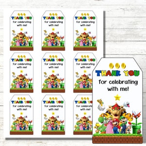 Puede incluir: Nueve etiquetas blancas de agradecimiento con una imagen de dibujos animados de Mario y sus amigos de la serie de videojuegos Super Mario. El texto en las etiquetas dice "&iexcl;Gracias por celebrar conmigo!"