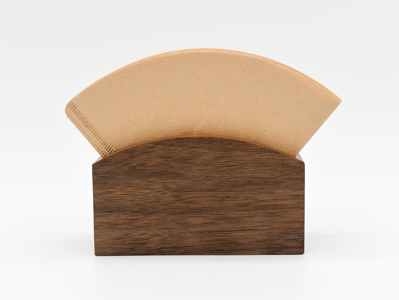 May include: A brown wooden coffee filter holder with a single brown paper coffee filter inside.