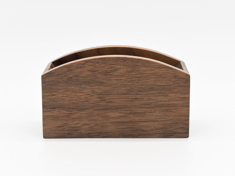 May include: A dark brown wooden box with a curved top. The box is made of wood with a natural grain pattern.