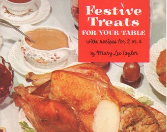 May include: A vintage cookbook titled "Festive Treats for Your Table" with recipes for 2 or 4 by Mary Lee Taylor. The cover features a roasted turkey with stuffing and gravy.