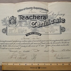 May include: A black and white teacher's certificate from Ocean County, New Jersey, dated May 1, 1894, for Samuel Van Tote, for the Third Grade. The certificate states that he has presented satisfactory evidence of good moral character and passed the required examination.
