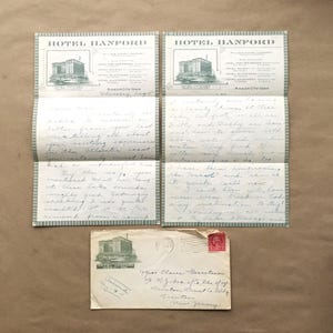 May include: A vintage postcard from the Hotel Hanford in Mason City, Iowa. The postcard features a black and white image of the hotel and the text "Hotel Hanford" in green lettering. The postcard is addressed to Miss Claire Harretton of N.J.  The postcard is dated Thursday, August.