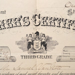 May include: A black and white teacher's certificate with the text "TEACHER'S CERTIFICATE" at the top. The certificate is for the third grade and is dated 1877. The certificate is signed by Samuel Van Note.