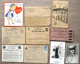 May include: A collection of vintage items from World War II, including ration books, a Valentine's Day card, a score book, and a photograph of a soldier. The items are arranged on a brown surface.