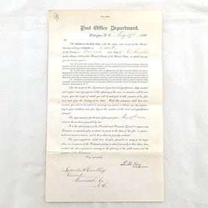 May include: A vintage off-white paper document titled Post Office Department, Washington, D.C., dated May 27th, 1880. The document features formal black printed text and handwritten cursive details, including a signature by the Postmaster General.