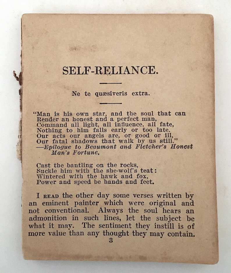 May include: A vintage, rectangular paper with the title "SELF-RELIANCE" in bold, black text. The paper has aged, with a light brown hue and visible wear along the edges. Text from the poem is printed below the title.