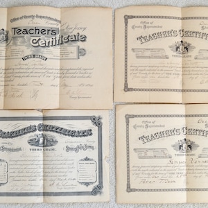 May include: Four vintage teacher's certificates from Ocean County, New Jersey. Each certificate is printed on paper with a decorative border and features the text "Teacher's Certificate" and "Third Grade".