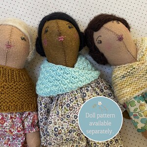 Three handmade dolls wearing handknit doll cowls and shawls.