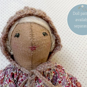 Handmade doll wearing handknit bonnet.