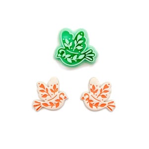 May include: A white ceramic mug with a black handle and the text "But First, Coffee" in a bold, black font. The mug is set against a blurred background, suggesting a cozy setting.