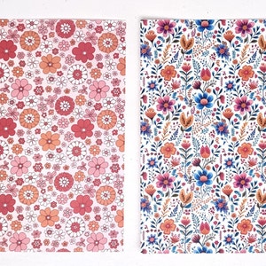 May include: Two floral patterned papers. The left paper has a pink background with a repeating pattern of flowers in shades of pink, red, and orange. The right paper has a white background with a repeating pattern of colorful flowers and leaves.