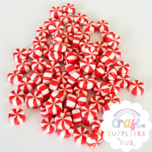 May include: A large pile of red and white candy cane-shaped polymer clay charms. The charms are about 1 cm in diameter and are perfect for adding a festive touch to crafts.