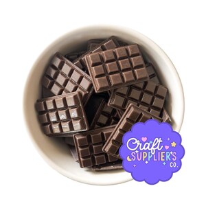 Pode incluir: Uma tigela branca cheia de várias peças pequenas retangulares castanho-escuras em forma de barra de chocolate, cada uma com uma grelha de doze quadrados. Um autocolante roxo recortado com o texto Craft Supplier's Co. está colocado no lado.