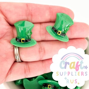 May include: Green leprechaun hats with black bands and gold buckles. The hats have a shamrock design on the top.