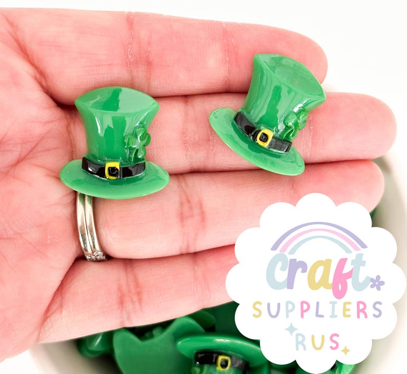 May include: Green leprechaun hats with black bands and gold buckles. The hats have a shamrock design on the top.