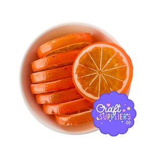 May include: A white bowl filled with a stack of translucent orange citrus slices. The slices have a visible segmented pattern and a glossy finish. A purple scalloped sticker with the text Craft SUPPLIER'S CO. is placed in the lower right.