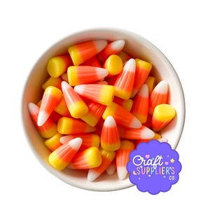 Könnte beinhalten: Eine weiße Keramikschüssel gefüllt mit Candy Corn. Die Süßigkeiten haben ein klassisches dreifarbiges Design mit weißen Spitzen, orangefarbenen Zentren und gelben Basen. Die Schüssel steht vor einem weißen Hintergrund. Ein lila Logo mit dem Text "Craft Supplier's Co." befindet sich unten rechts.