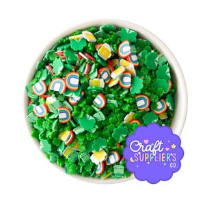 May include: A white bowl filled with colourful polymer clay pieces. The clay pieces include green shamrocks, rainbows, and beer mugs. The image also includes a purple logo that says "Craft Supplier's Co."