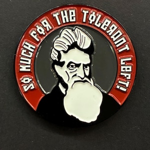 May include: A round, black and red coin with the text "SO MUCH F*R THE TOLERANT LEFT!" encircling a portrait of a man with a white beard and hair. The coin has a glossy finish.