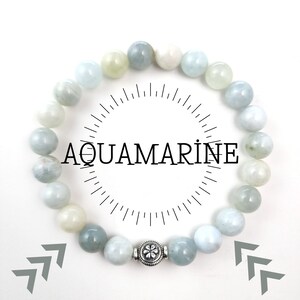 May include: A light blue aquamarine gemstone bracelet with a silver charm. The bracelet is made of round beads and has a silver clasp.