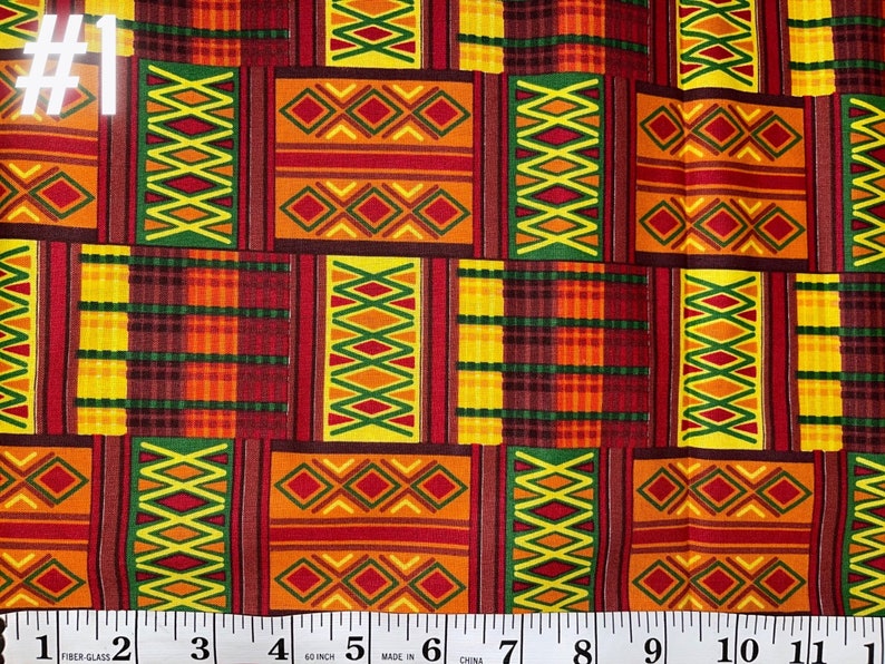 May include: A close-up of a colourful fabric with a geometric pattern in shades of red, orange, yellow, and green. The fabric has a repeating pattern of squares and diamonds. The fabric is measured with a ruler, showing that it is 60 inches wide.