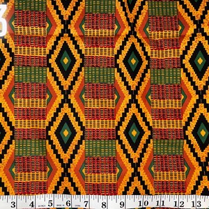 May include: A close-up of a fabric with a repeating pattern of black, yellow, red, and green diamonds. The fabric is measured with a ruler in inches.