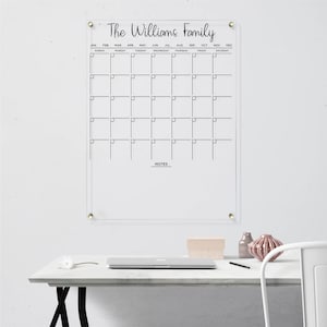 Personalized acrylic wall calendar with black detailing, featuring a monthly layout and a notes section.