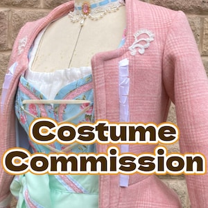Könnte beinhalten: Eine rosa-weiß karierte Jacke mit weißer Spitzenborte und einem weißen Rüschendetail. Die Jacke wird über einem weißen und blauen Blumenkorsett und einem hellgrünen Rock getragen. Der Text "Costume Commission" ist über das Bild gelegt.