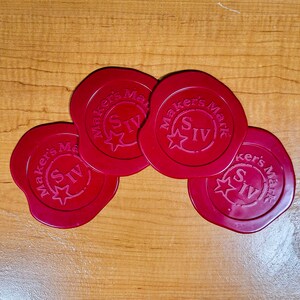May include: Four red wax seals with the text "Maker's Mark" and a star with the Roman numeral "IV" in the center.