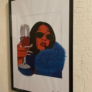 May include: A digital illustration of a woman with red hair and sunglasses wearing a blue fur coat and holding a glass of red wine. The image is signed "Sunnie Drew" and "@wondering.graphics".