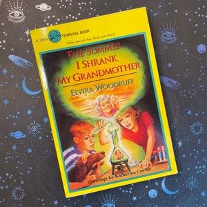 May include: A yellow paperback book with a colourful illustration of a child shrinking their grandmother. The book title is "The Summer I Shrank My Grandmother" by Elvira Woodruff.