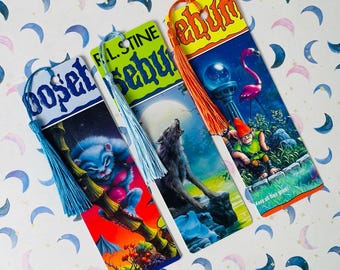 May include: Three rectangular bookmarks featuring Goosebumps book cover art. The left bookmark has a blue tassel and a blue creature. The middle bookmark has a light blue tassel and a howling wolf. The right bookmark has an orange tassel and a garden gnome.