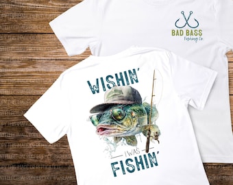 May include: Two white t-shirts, one with a fishing hook logo that says "Bad Bass Fishing Co." and the other with a cartoon fish wearing sunglasses and a hat that says "Wishin' I Was Fishin'"
