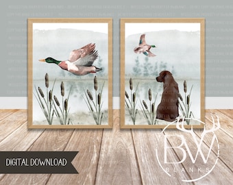 May include: Two watercolor prints in brown frames. The left print features a green and brown duck flying over a pond with cattails. The right print features a brown dog sitting by a pond with cattails. The prints are labeled "BW Blanks" at the bottom.