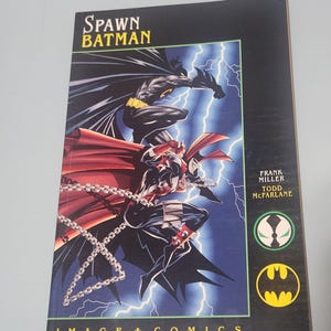 May include: A Spawn Batman comic book featuring cover art of the two characters against a dark blue background with lightning bolts. The title Spawn Batman is printed at the top, with Frank Miller and Todd McFarlane credited on the right side.