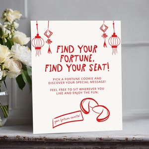 May include: White sign with red text that says "Find your fortune, find your seat!"  Pick a fortune cookie and discover your special message! Feel free to sit wherever you like and enjoy the fun.  Your fortune awaits!  There are red Chinese lanterns and fortune cookies drawn on the sign.