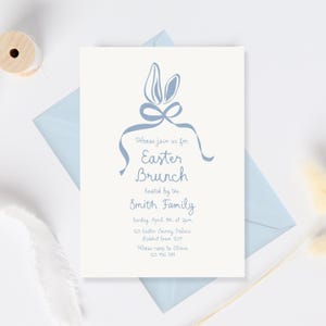 May include: A blue and white Easter brunch invitation with bunny ears and a bow. The invitation reads "Please join us for Easter Brunch hosted by the Smith Family. Sunday April 7th at 2pm. 123 Easter Bunny Palace Rabbit town 1231. Please RSVP to Olivia 123 456 789"