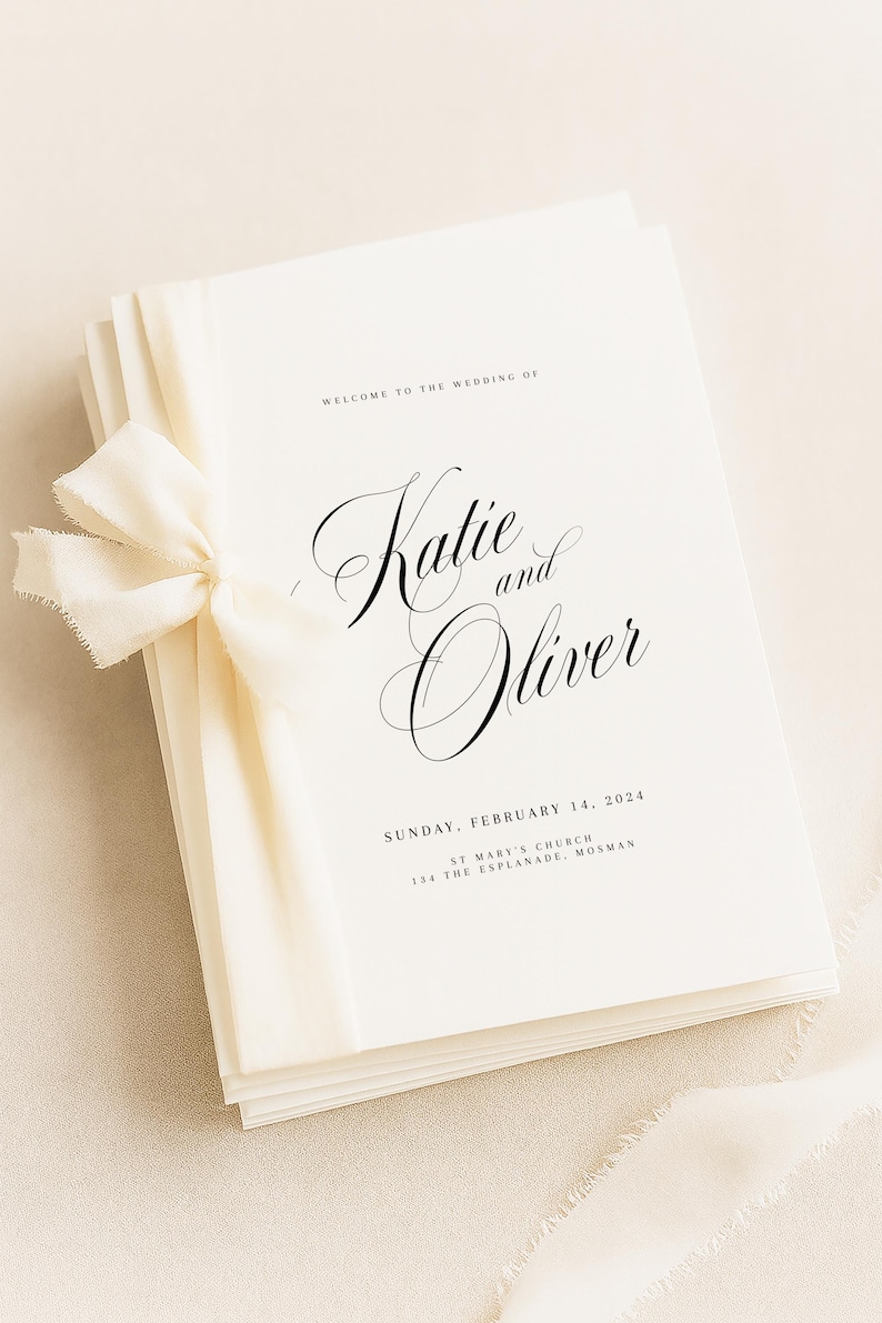 May include: A stack of cream-colored wedding programs tied with a matching frayed-edge ribbon. The text reads: Welcome to the wedding of Katie and Oliver, Sunday, February 14, 2024, St Mary's Church, 134 The Esplanade, Mosman, in black serif font.
