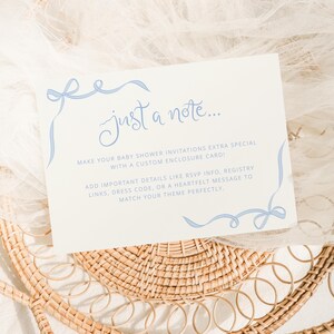 Puede incluir: Una tarjeta blanca con detalles de cinta azul y el texto "just a note..."  ¡Haz que tus invitaciones de baby shower sean extra especiales con una tarjeta de inclusión personalizada! Agrega detalles importantes como información de RSVP, enlaces de registro, código de vestimenta o un mensaje sincero para que coincida perfectamente con tu tema.