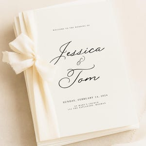 May include: Wedding programs with the names "Jessica & Tom" in script, dated February 14, 2024. The programs are bound with a cream ribbon. The text "WELCOME TO THE WEDDING OF" is at the top.