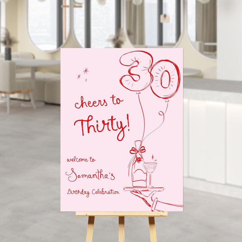 May include: Pink birthday party sign with red text that says "Cheers to Thirty!" and "Welcome to Samantha's Birthday Celebration". The sign also features a drawing of two red balloons shaped like the number 30 and a bottle of champagne on a tray.