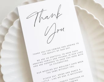 Op de afbeelding: Een eenvoudige, elegante bedankkaart voor een huwelijksreceptie. De kaart heeft een handgeschreven "Dank je wel" in zwarte cursieve letters en een boodschap waarin de gasten bedankt worden voor hun aanwezigheid op de bruiloft. De kaart is gedrukt op wit papier.
