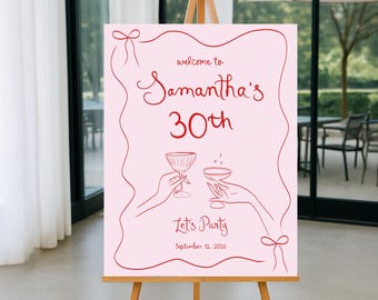 May include: Pink welcome sign with red text that says "Welcome to Samantha's 30th. Let's Party. September 12, 2026". The sign features a stylized illustration of two hands holding champagne glasses.