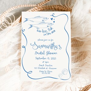 Può includere: Un invito bianco con testo blu e illustrazioni di pesci. L'invito recita "Two less Fish in the sea" ed è per il bridal shower di Samantha il 15 settembre 2025 alle 14:00 presso il Beach Pavilion. L'indirizzo è 1125 Elizabeth st. Mossman. RSVP a Olivia al 123.456.789.