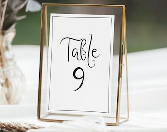 May include: A gold-toned metal frame with a white card inside. The card has black text that reads "Table 9".