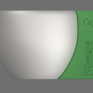 May include: A white ceramic mug with a green rim and the text "Cafe" and "N Designs MC Creations" on the side.