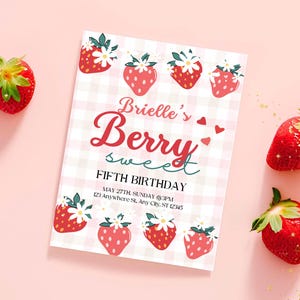 May include: A pink and white gingham-patterned invitation with strawberry illustrations. The text reads "Brielle's Berry Sweet Fifth Birthday." Fresh strawberries with green stems are scattered around the invitation on a pink background.
