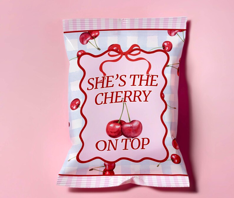 May include: A pink and white checkered bag with a pink label that says "She's the cherry on top" with a red bow and cherries on the bag.