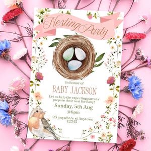 May include: A white baby shower invitation with a pink banner that says "Nesting Party". The invitation features a watercolor illustration of a bird's nest with three eggs, a robin, and floral accents. The text on the invitation reads "In honor of Baby Jackson, Let us help the expecting parents prepare their nest for Baby! Sunday, 5th Aug @6pm, 123 anywhere st Anytown 12345."