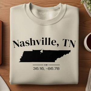 May include: A set of three ceramic mugs with a speckled, matte finish. The mugs are in shades of cream, light gray, and dark gray. Each mug has a simple, minimalist design and a rounded handle. Perfect for coffee or tea.